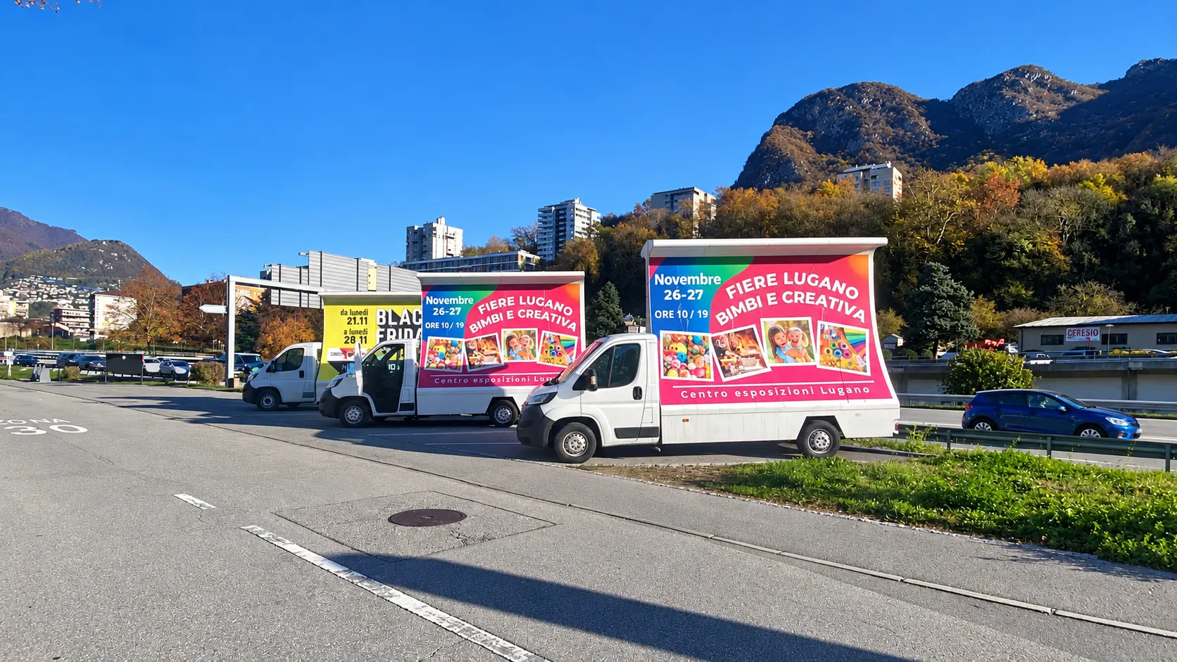 Tre camion vela per una fiera a Lugano in un parcheggio autunnale